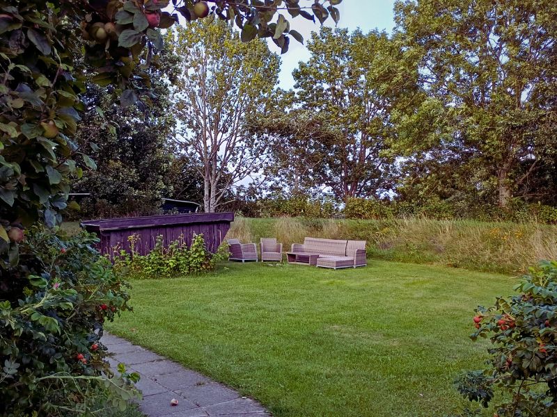 Et kig mod volden med shelter og havemøbler